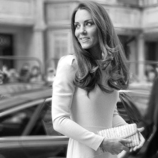 Black and white photograph of a woman smiling while holding a clutch bag, standing in front of a car.
