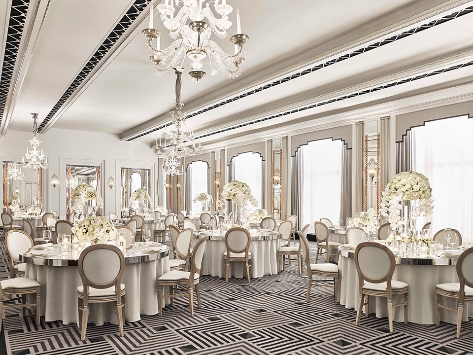 Chairs and tables are lavishly decorated with floral arrangements in the elegant Art Deco Ballroom of Claridge's Hotel.