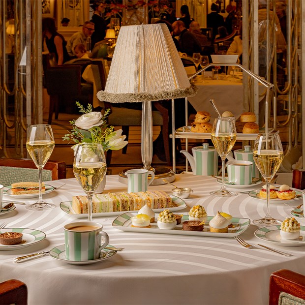 A lavish afternoon tea spread at Claridge’s, featuring artful patisserie, sparkling champagne, and a perfectly curated table setting, embodying the timeless elegance of this London institution.