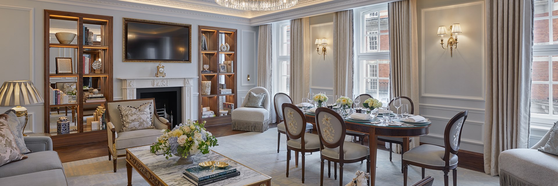 The living room at Brook Suite at Claridge's with dining table, dining chairs, sofa, coffee table, and TV on the wall