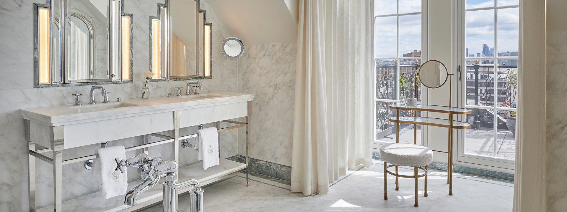 The Mews Pavilion at Claridge's -bathroom view with floor to ceiling marble with two bath sinks and view of the roofs of London.
