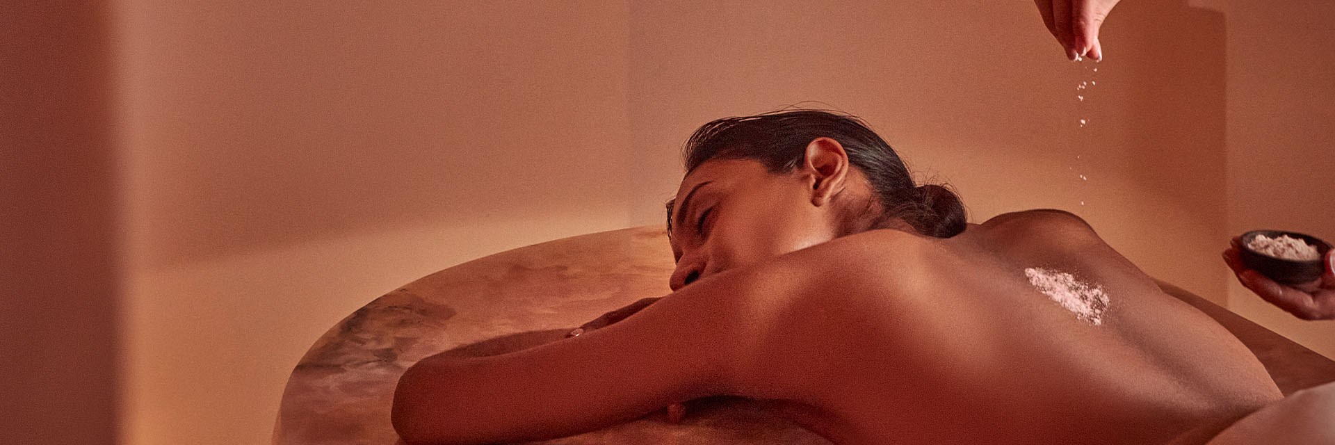 woman having treatment on pink onyx bed