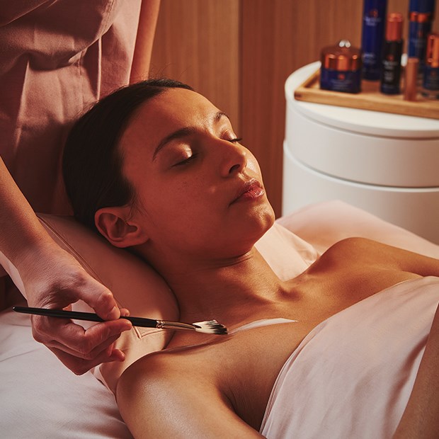 A view of a girl enjoying a gentle treatment from Claridge's Spa, with a wellness professional applying the treatment.
