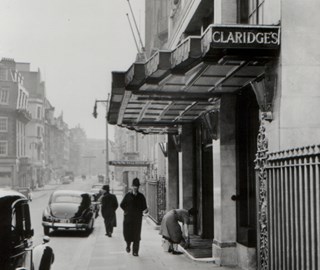 A black and white photo in front of Claridge's Hotel and the passers-by at that time as part of history.