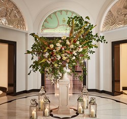 Dramatic display of Claridge's flowers by the ballroom, in an elevated pillar vase, surrounded my lanterns