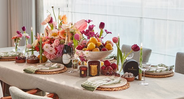 Colourful tablescape with pink, orange, red and yellow decor adorning the fully decorated table