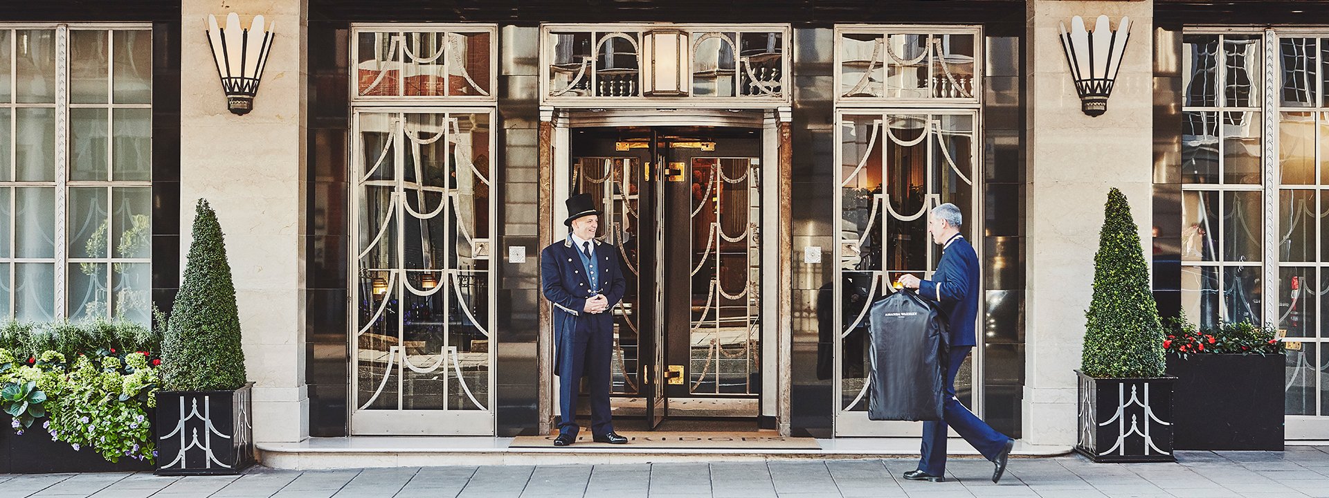 View of the meeting between the smiling doorman and the concierge in front of Claridge's Hotel.