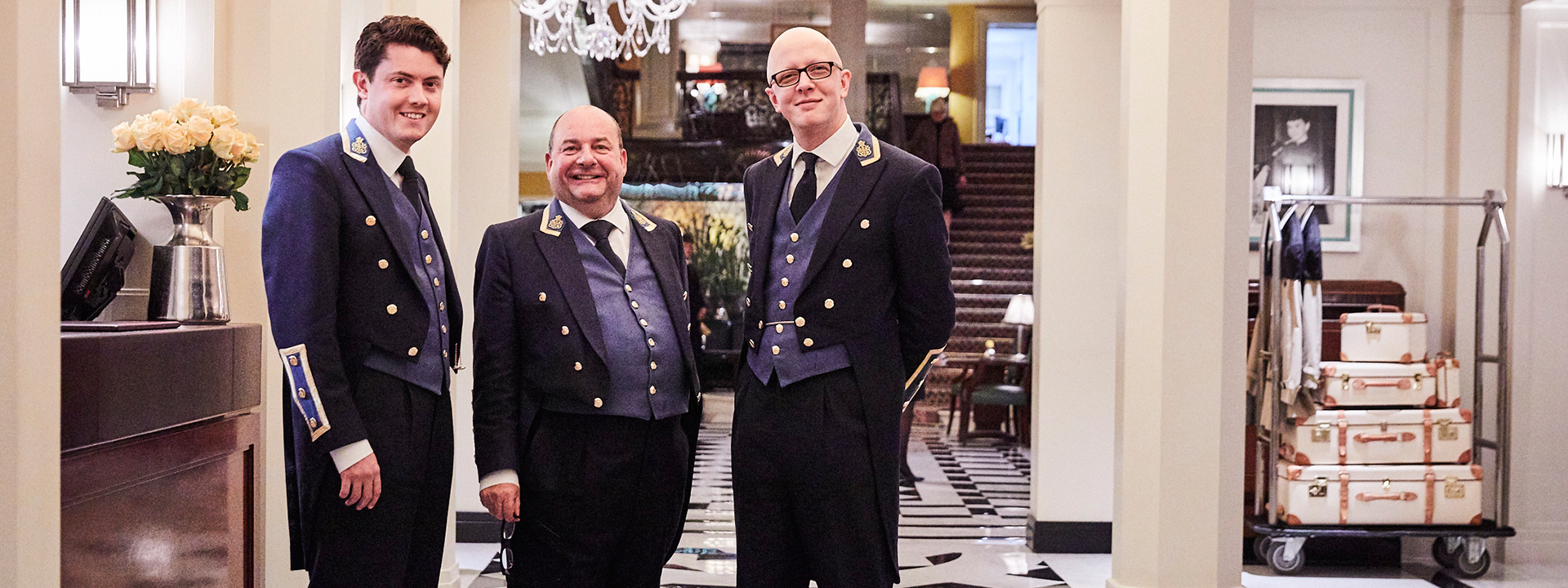 Smiling concierge team waiting for their guests at Claridge's Hotel.