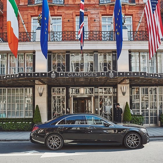 View from the outside, of the entrance in front of Claridge's Hotel and the car parked outside with the doorman.