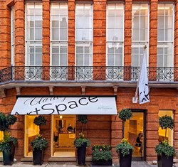 Exterior of Claridge's ArtSpace, white awning and red brick building.