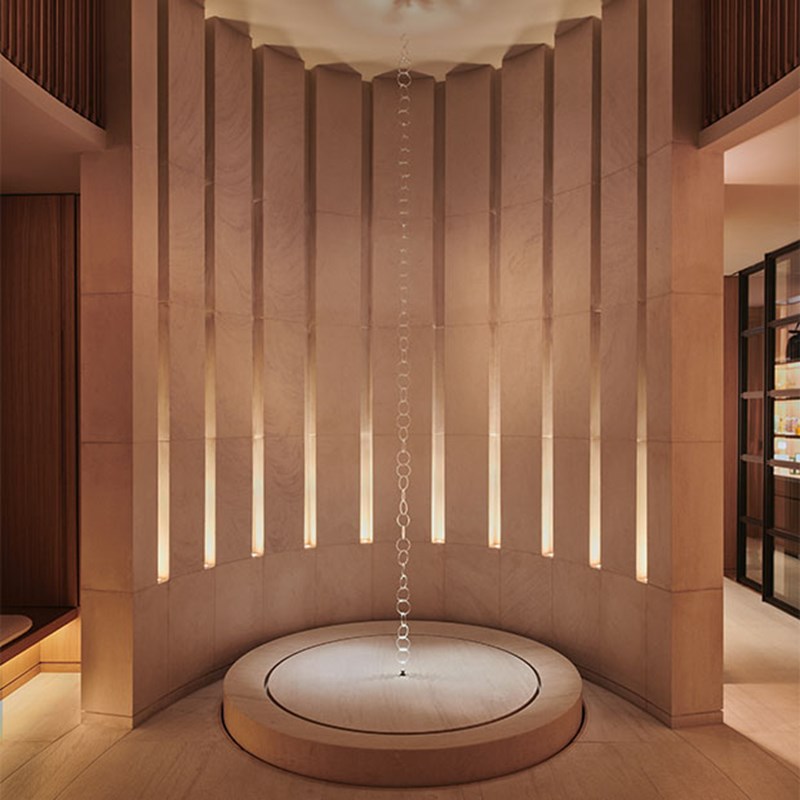 The entrance to Claridge's Spa which is a tall sculpture with a vertical chain and wood surrounds