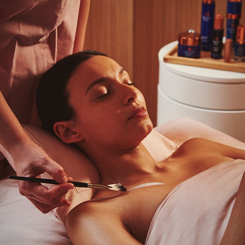 A view of a girl enjoying a gentle treatment from Claridge's Spa, with a wellness professional applying the treatment.