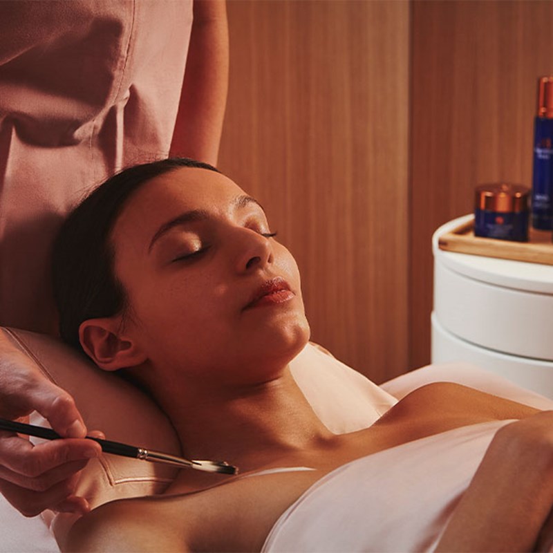 A view of a girl enjoying a gentle treatment from Claridge's Spa, with a wellness professional applying the treatment.