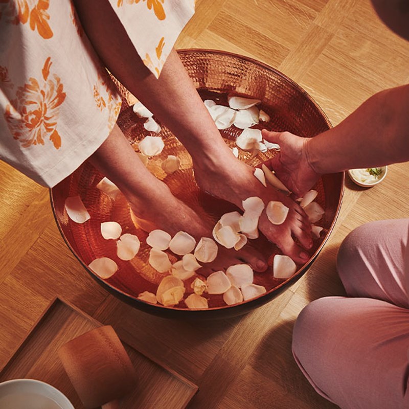 Claridge's Spa welcome foot ritual, copper bowl with a ladies feat in it, with water and petals