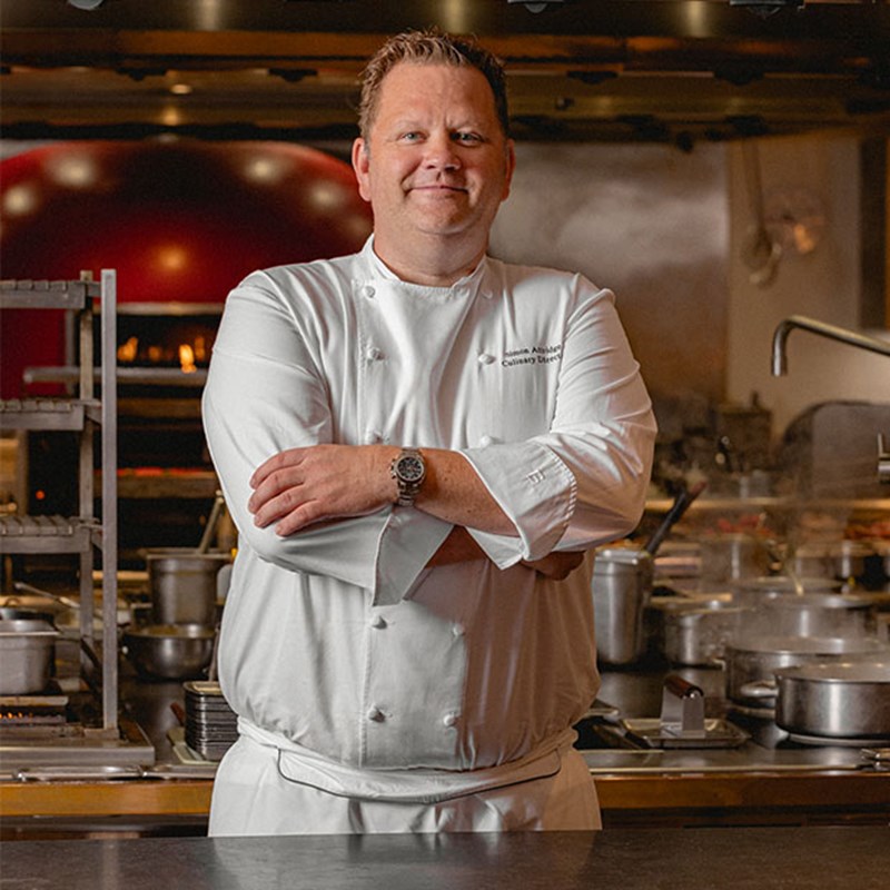 Simon Attridge, culinary director at Claridge's, smiling in his chef whites.