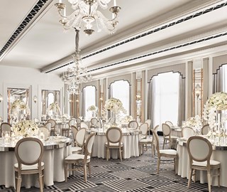 Chairs and tables are lavishly decorated with floral arrangements in the elegant Art Deco Ballroom of Claridge's Hotel.