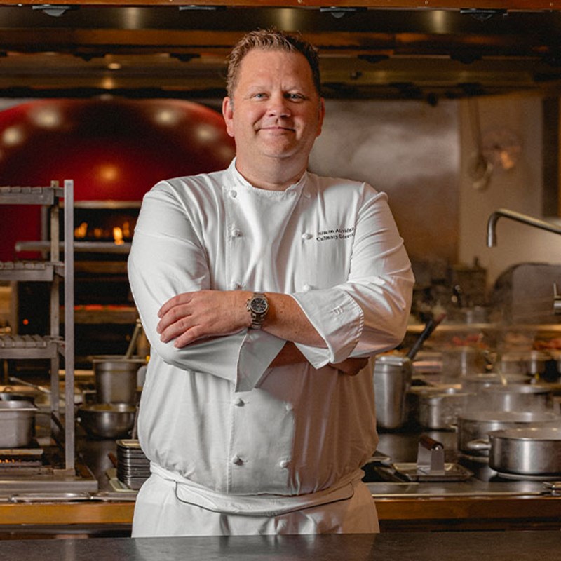Simon Attridge, culinary director at Claridge's, smiling in his chef whites.