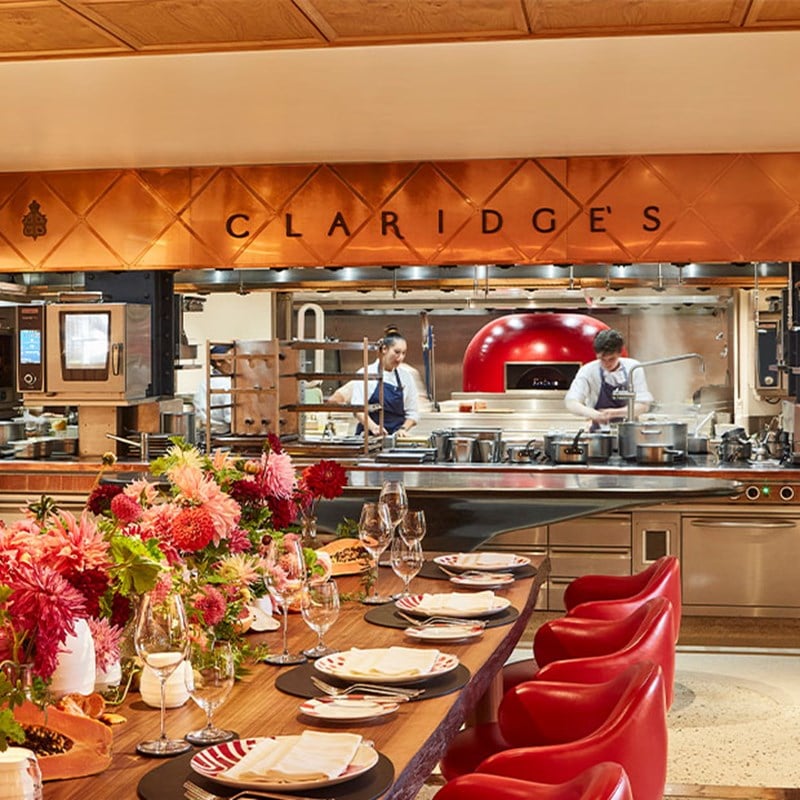 L'Epicerie, with an immersive setting, table laid up with flowers and an open kitchen with a sign saying 'Claridge's'