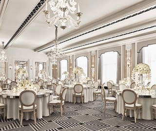 Chairs and tables are lavishly decorated with floral arrangements in the elegant Art Deco Ballroom of Claridge's Hotel.