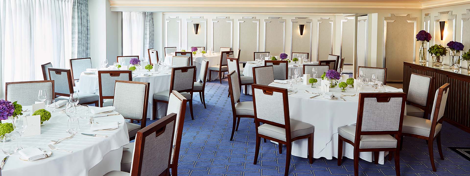 Part of the Clarence Room, in Art Deco design, with comfortable chairs and tables, enriched with natural daylight.