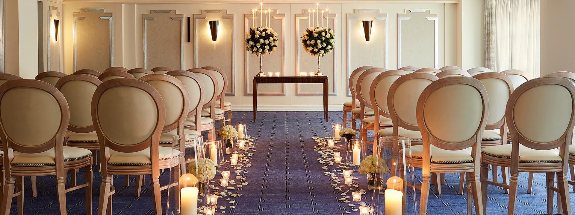 Part of the Clarence Room, in Art Deco design, decorated with candles and flowers perfect for a wedding.
