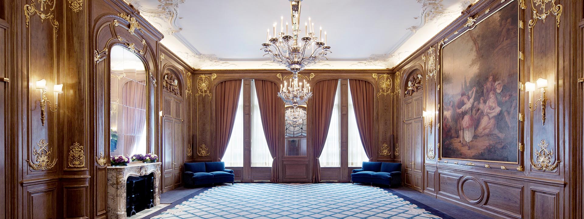 View of the French Salon and original marble mantelpiece, as well as elegant chandeliers.