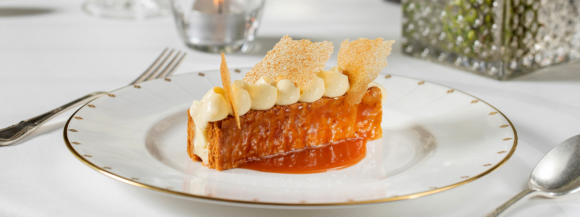 Mille-Feuille with vanilla pastry cream and bourbon sauce on a white plate with golden edges.