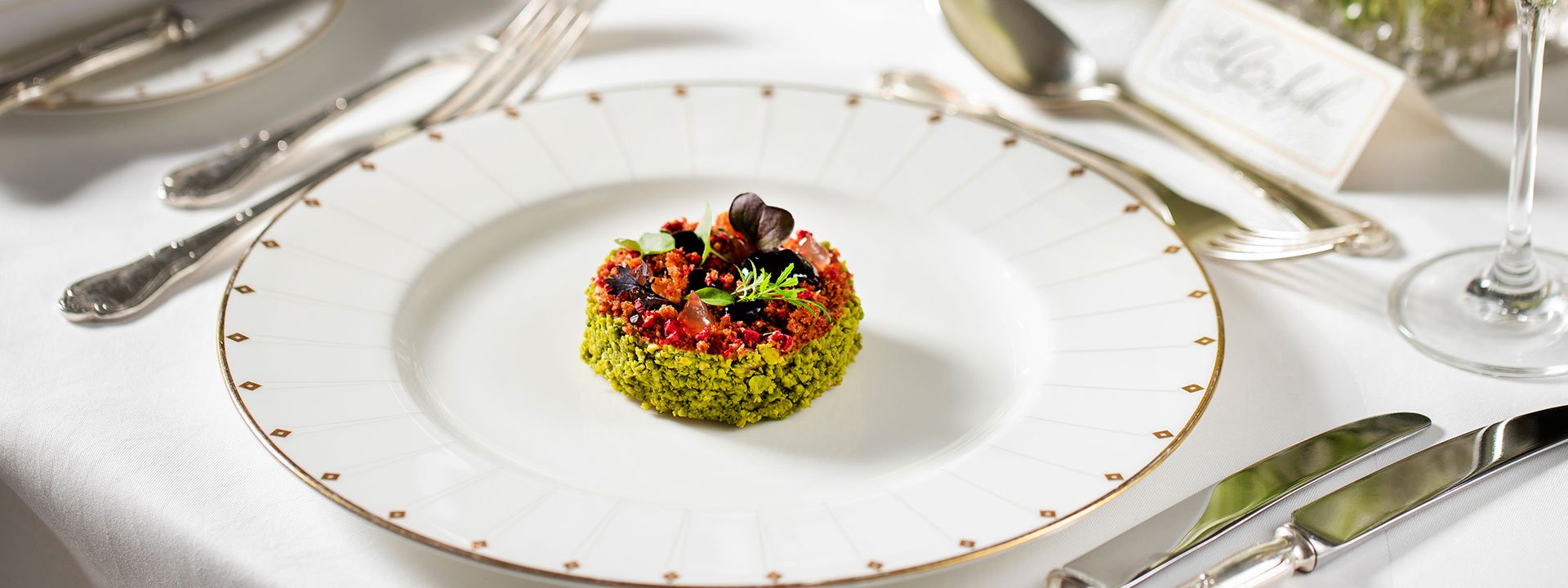 A delightful foie gras at Claridge's Hotel, in an explosion of green and red colours served on a white plate with gold edges.