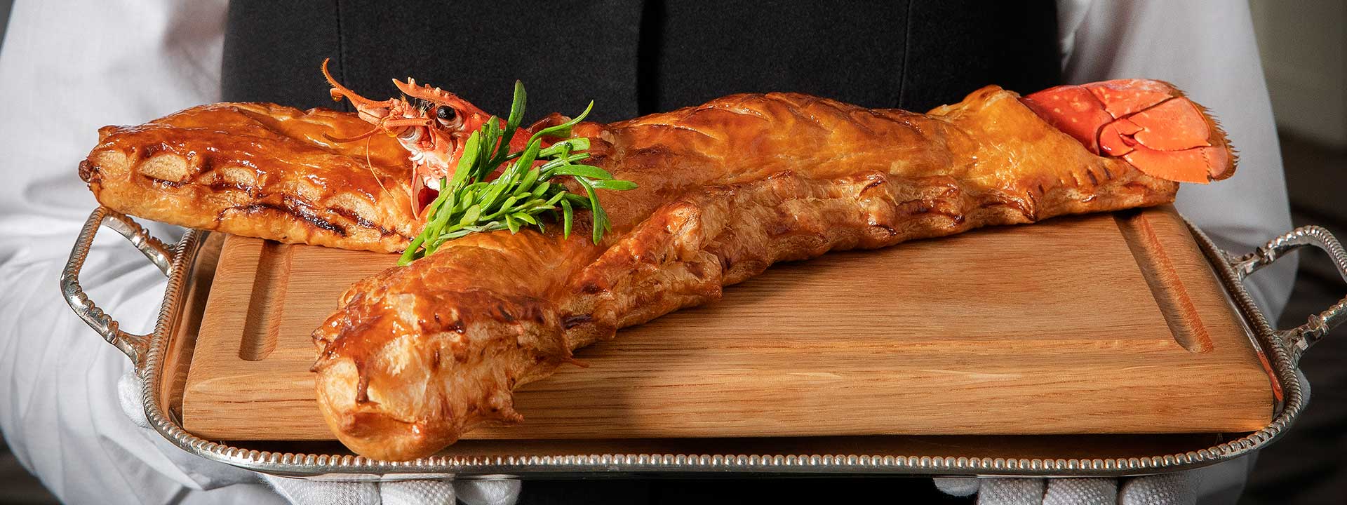 Hotel Claridge's Lobster Wellington, a gastronomic miracle baked in a delicious batter, served on a tray.