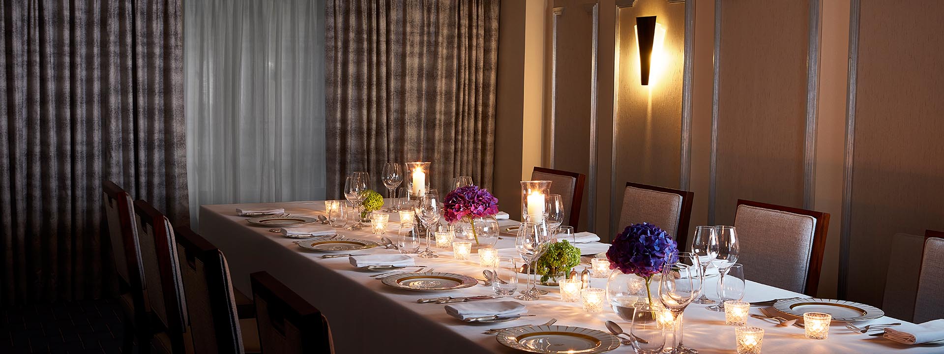 A view of the luxuriously set table with floral arrangements and lit candles in the St James Room.