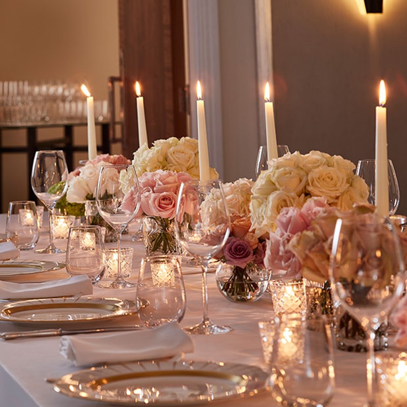 A luxuriously decorated dining table with candles and flower arrangements in a romantic atmosphere.