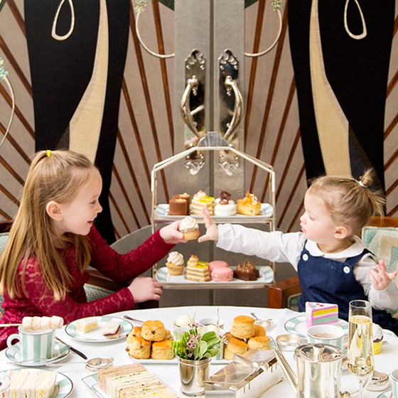 Two children sharing afternoon tea in Mayfair at Claridge's