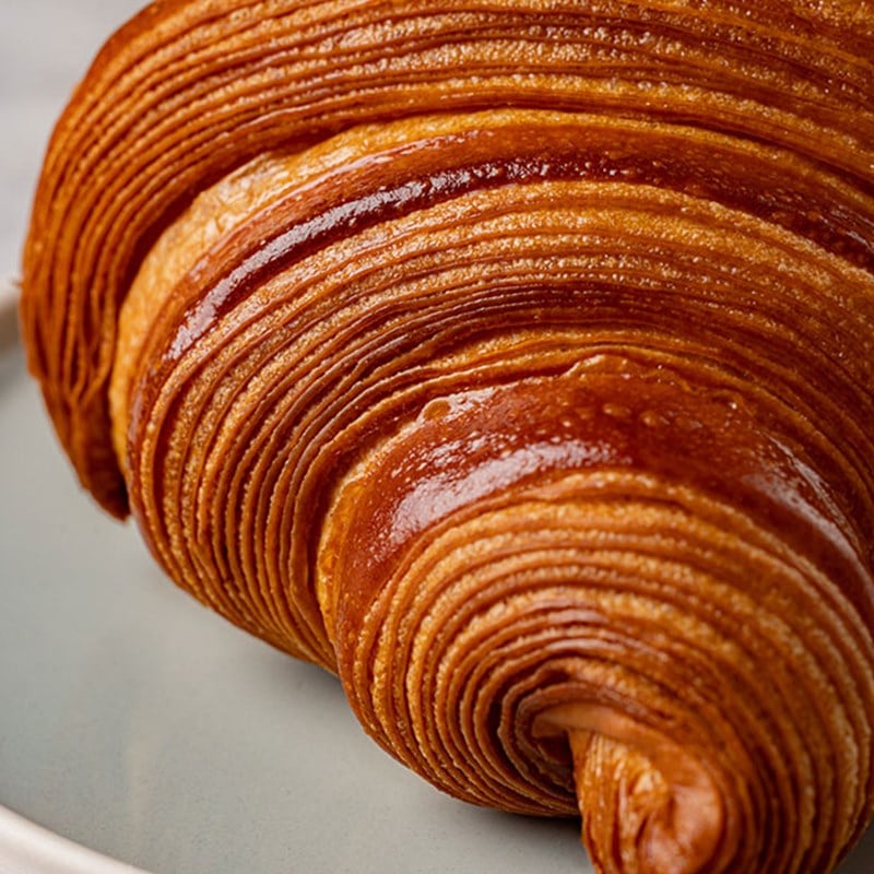 detail of croissant's flaky pastry showing the swirls and layers