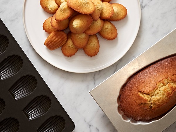 A plate of madeleines next to a giant madeleine.