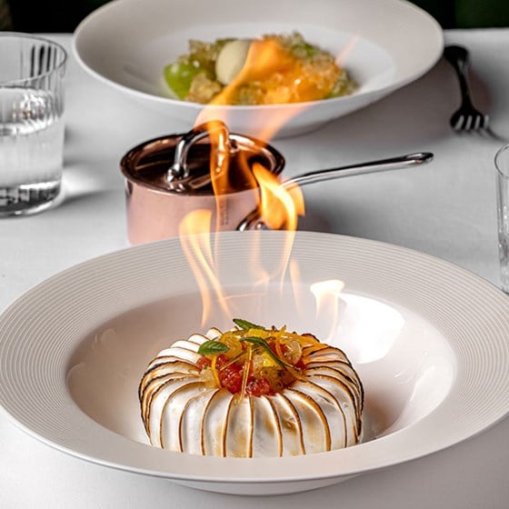White dessert being flambeed on a plate