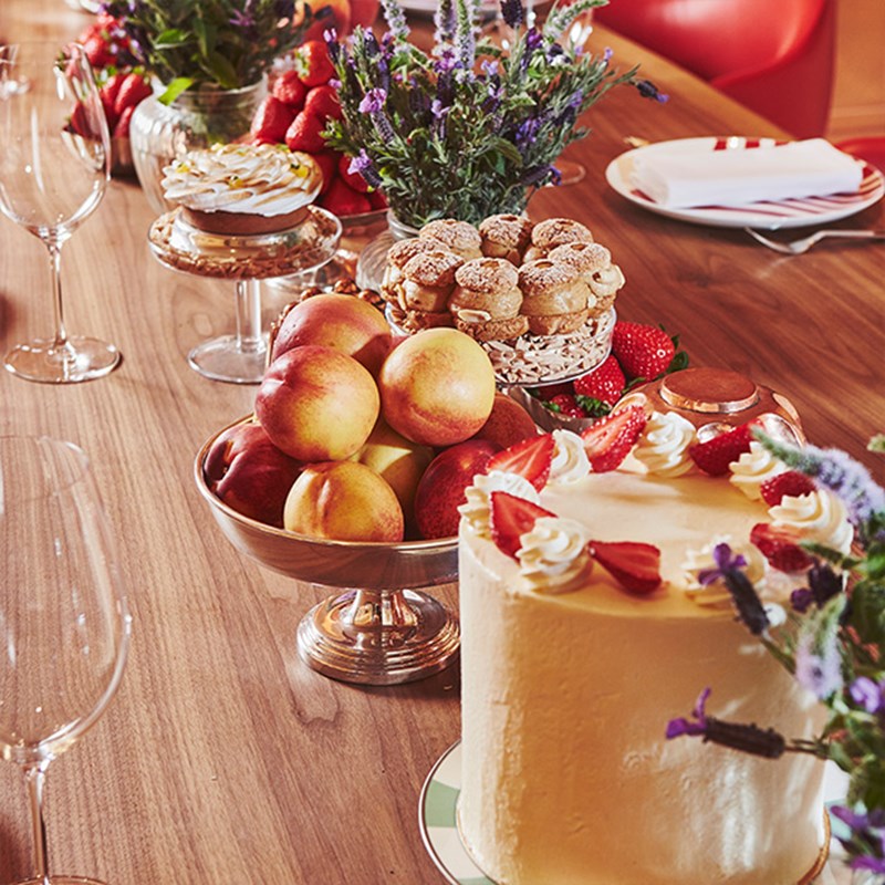 Bowls of peaches and delicate cakes on a the Chef's table in L'Epicerie