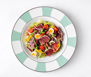 A dish with beef, quail eggs, tomatoes, and chicory at The Foyer Private Dining Room.