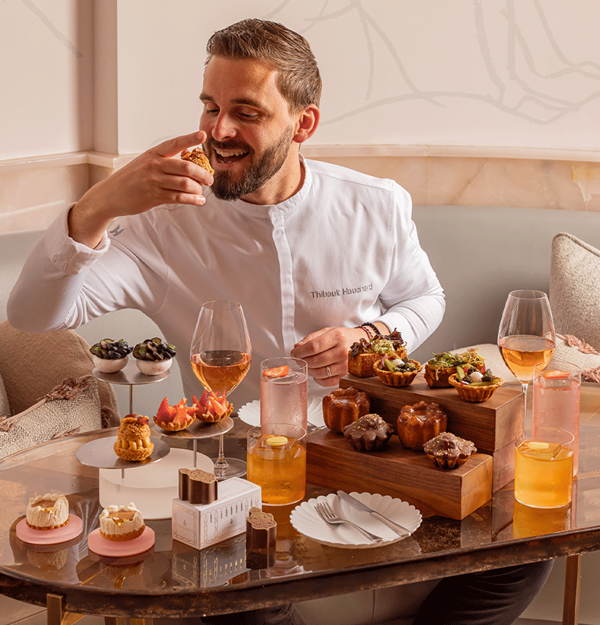 Chef Thibault Hauchard enjoying an elegant afternoon tea at Claridge’s, surrounded by artfully plated sweet and savoury pastries, fruit tarts, and cocktails in The Painter’s Room.