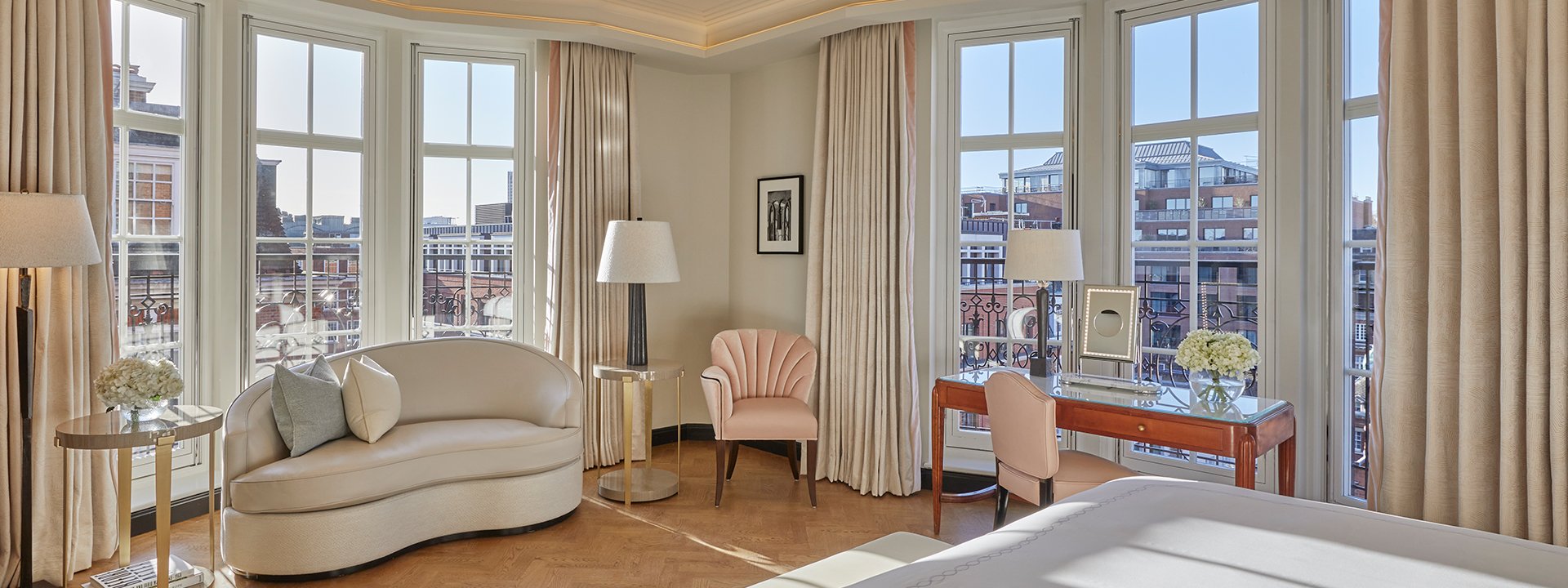 Corner Terrace Suite at Claridge's - room with bed, couch next to the window, armchairs and a view on London rooftops.
