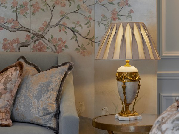 A table lamp next to the sofa with beautifully embroidered cushions.