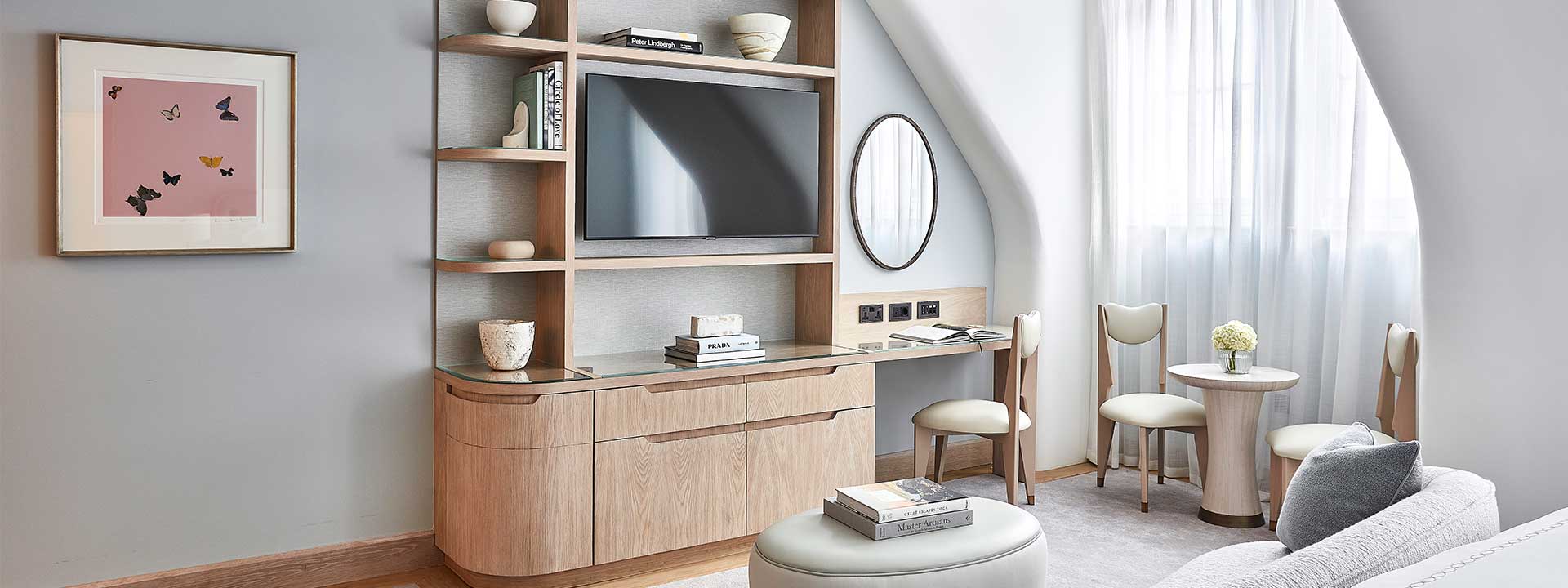 Part of Claridge's Balcony Room, with a large TV, comfortable chairs, and classic interior details.