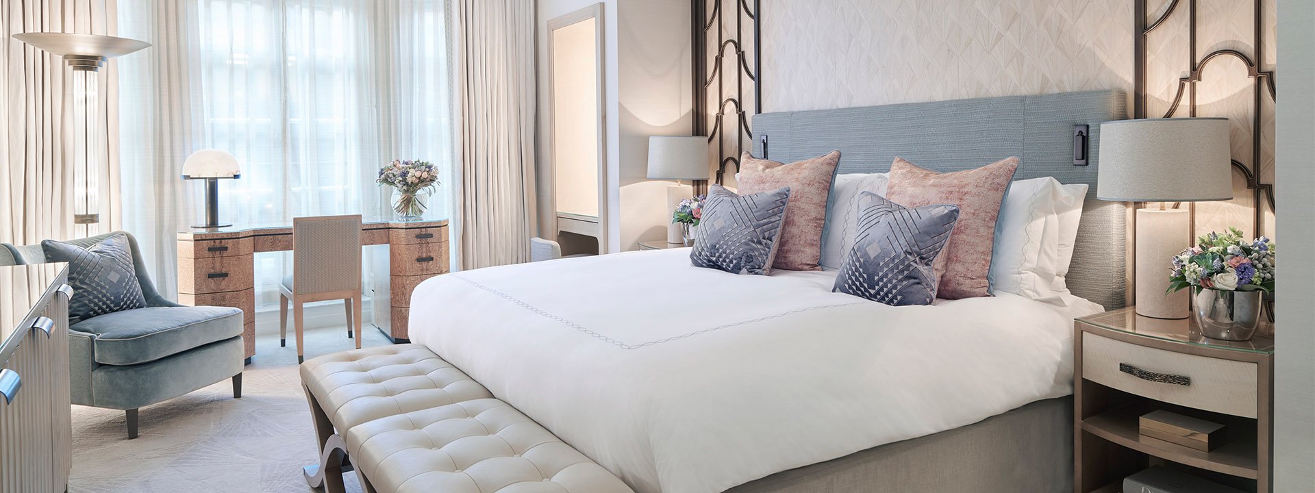 A view of a King Bed, armchairs and a classic interior with art deco elements in an elegant design at Claridge's.