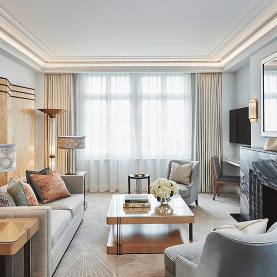 An elegant living room interior, with plenty of art deco elements and a space filled with daylight in Claridge's Suite.