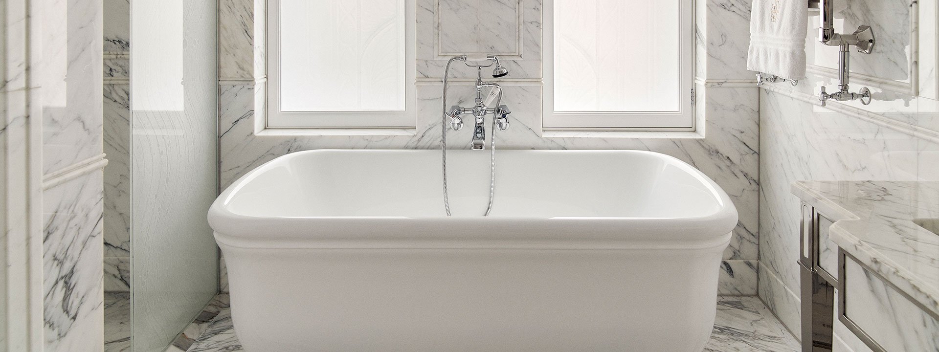 A view of the bathtub in the luxurious marble bathroom of the Corner Suite, perfect for relaxation.