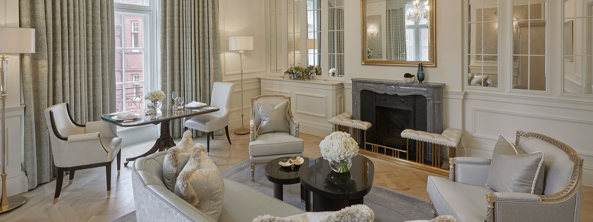 Sitting room with large bay windows, a palette of beige colours, and luxurious details in the Corner Suite.