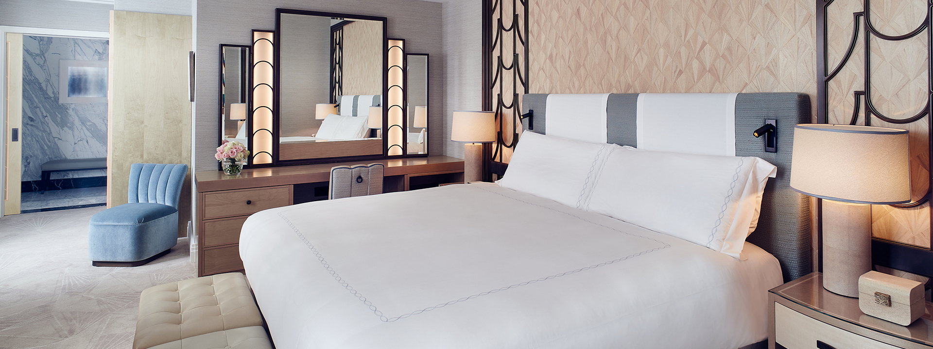 King Bed in the spacious bedroom of the Deluxe Junior Suite, surrounded by luxurious details and a comfortable armchair.
