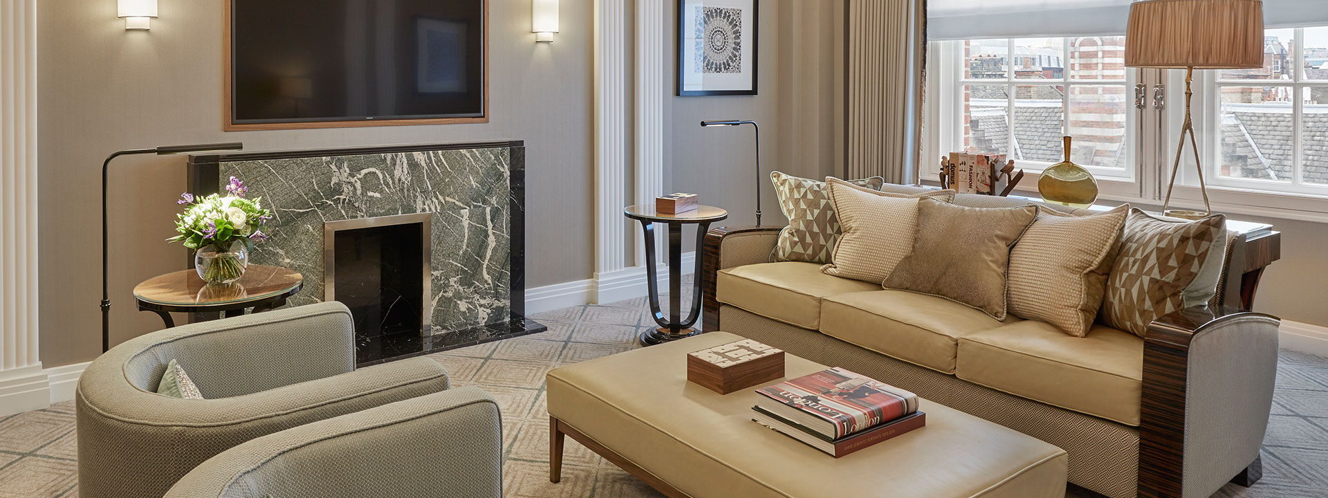 Sitting room in Claridge's Suite with comfortable furniture including an ornate fireplace.