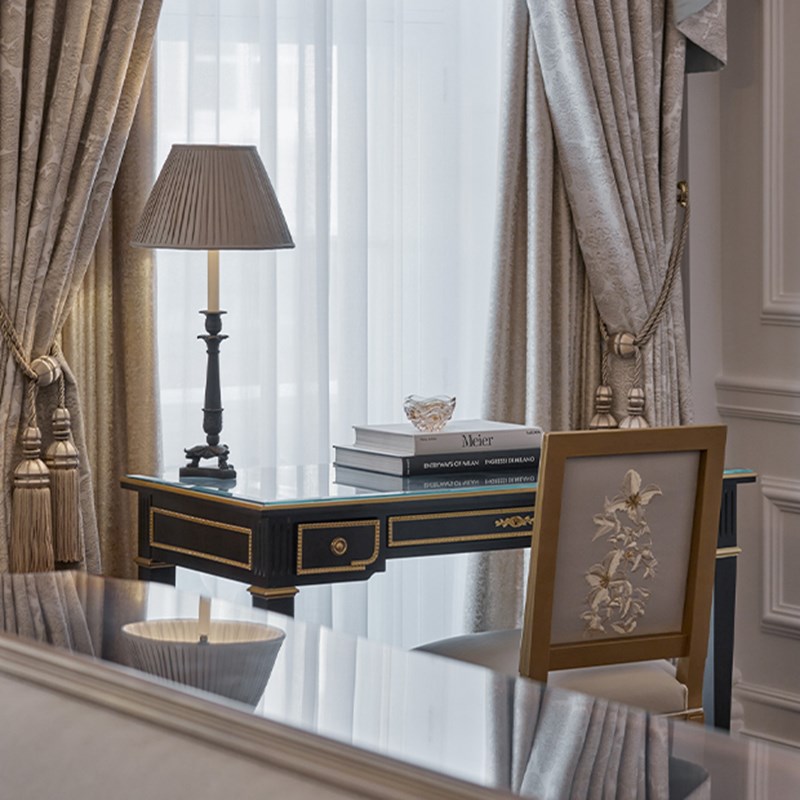 A desk with books and a lamp at the Georgian Suite at Claridge's