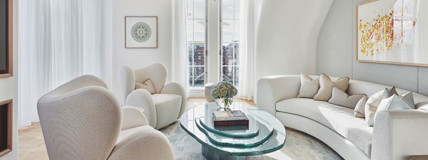 White sofas and doors opening to terrace in suite living area