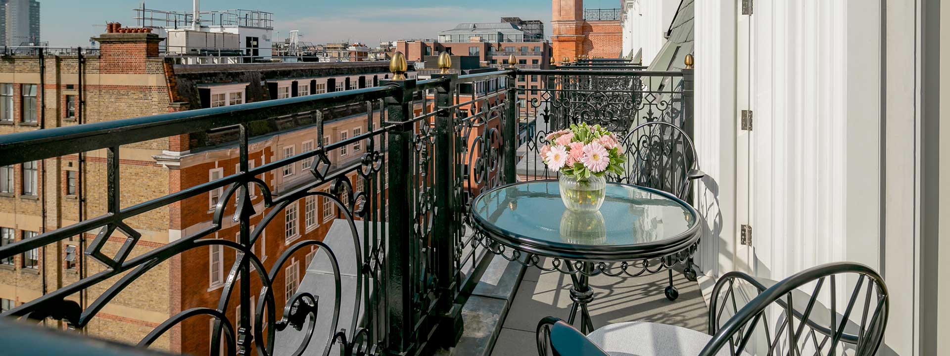 Enjoying the view on the terrace from the Mayfair Balcony Room, on comfortable chairs and with flower arrangements.